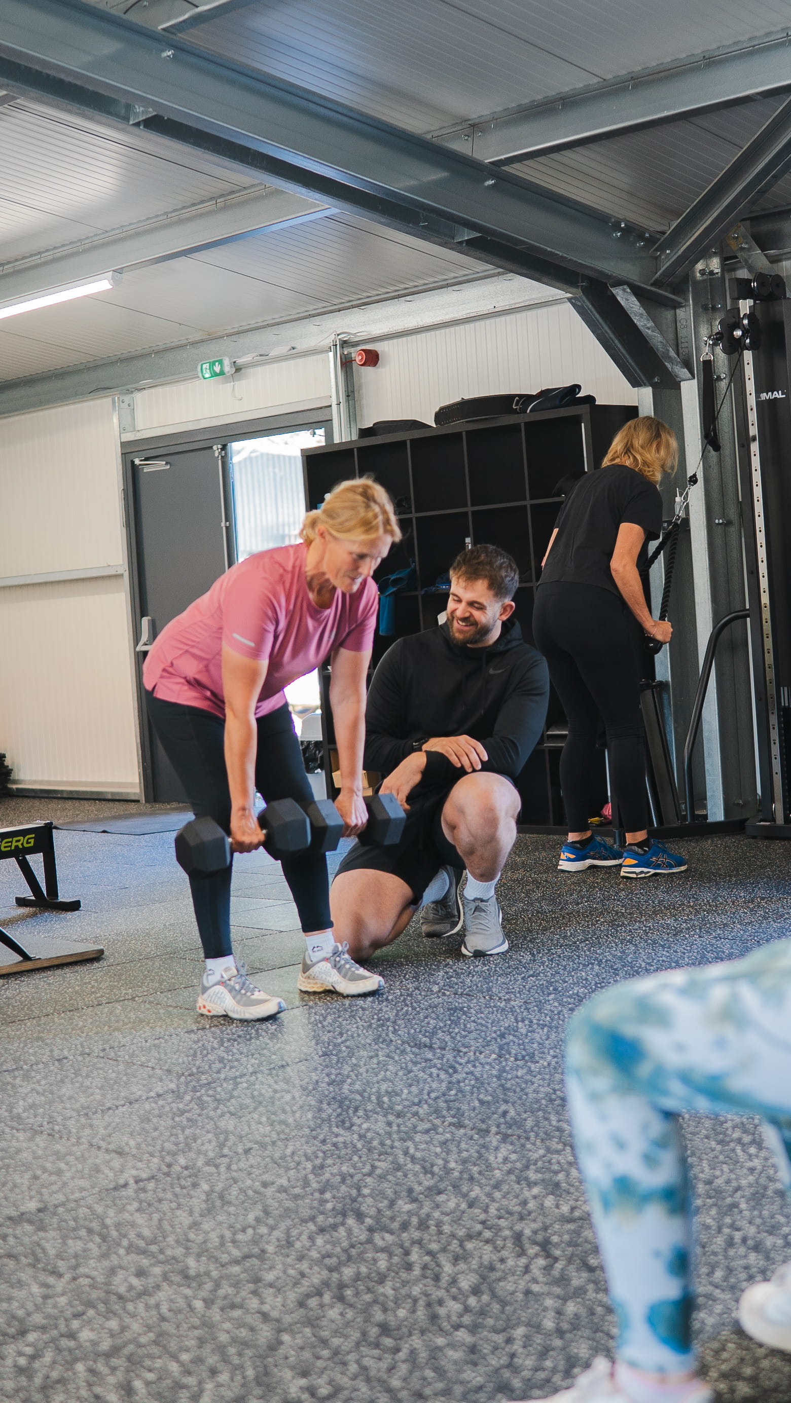 Personal trainer with client in gym